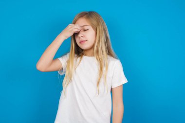 Üzgün, beyaz, tişört giyen, baş ağrısından muzdarip güzel bir kız.