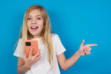 Telefonunu tutan ve boş fotokopi alanını işaret eden tişört giyen beyaz güzel bir kız.