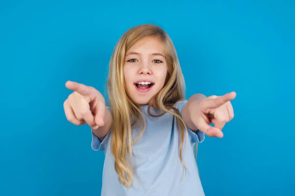 Close-up portrait of surprised girl  pointing with two fingers to the camera saying: I choose you!, looking up with open mouth.