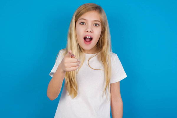 Shocked   beautiful caucasian girl wearing t-shirt    points at you with stunned expression