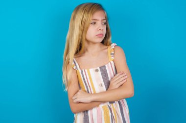 Kötü tavırlı, kollarını yana kavuşturmuş, güzel, beyaz bir kız. Negatif insani duygu yüz ifadesi.