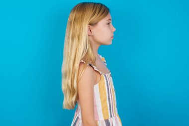 Sağlıklı ciltli güzel beyaz elbiseli güzel bir kızın profili. Düşünceli bir ifadesi var. Açık havada yürümeye hazır..