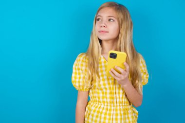 Elbise giyen güzel beyaz kız cep telefonu kullanıyor yüksek hızlı internet kullanıyor ve sosyal ağlar çevrimiçi iletişime sahip. Modern teknoloji kavramı