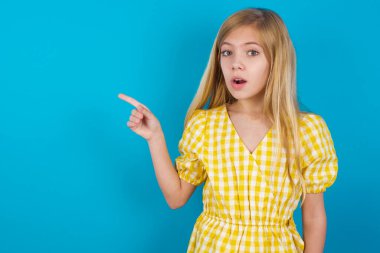 Emotif güzelliğindeki beyaz elbiseli kız, şok yüzünden çenesini düşük tutuyor. Bu da boş alandaki tanıtım noktalarını gösteriyor ki büyük bir alışveriş satışı var. Reklam.