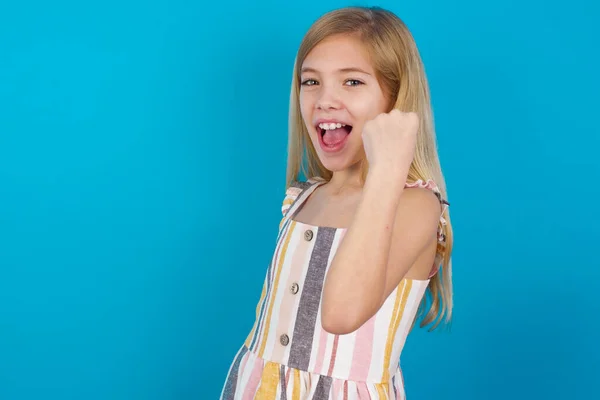 Overjoyed girl  glad to receive good news, clenching fist and making winning gesture.