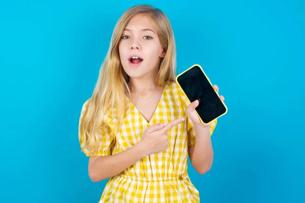 Menina Branca Bonita Animado Segurando Apontando Com Dedo Para Smartphone — Fotografia de Stock