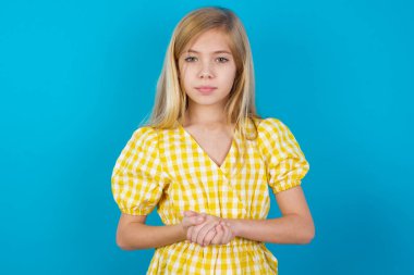 Neşeli, kendinden emin beyaz bir kızın kollarıyla elbise giydiği bir fotoğraf.