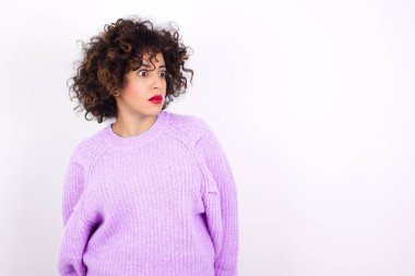  Süveter giyen genç ve güzel bir İspanyol kadın şaşırmış bir ifadeyle yan yana bakıyor. Nutku tutulmuş gibi. Utangaç model şaşırmış görünüyor.