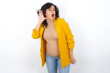 - Aman Tanrım! Komik, şaşkın hamile iş kadını sarı ceketli, ağzı geniş bir şekilde yana bakıyor, eli kulağında, dedikoduları dinlemeye çalışıyor..