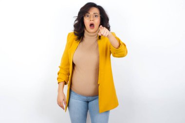 Şok olmuş hamile kadın işaret parmağıyla kamerayı işaret ediyor ve... Sürpriz ve reklam konsepti.