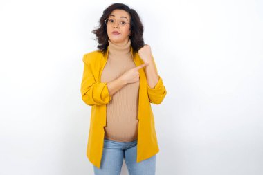 Acele eden hamile bir kadın zamanı, sabırsızlığı ve gecikmeyi izlemek için işaret ediyor.