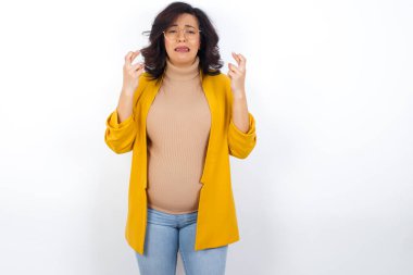 Hamile bir kadın endişeli bir ifadeyle işyerinde hata görmemesini umuyor..