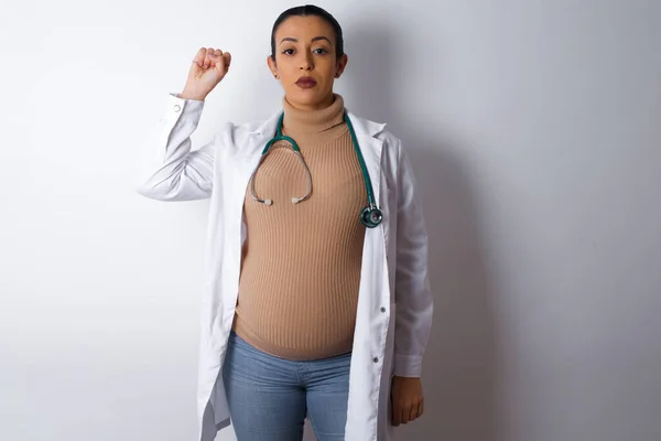 Mulher Médica Grávida Sentindo Séria Forte Rebelde Levantando Punho Protestando — Fotografia de Stock