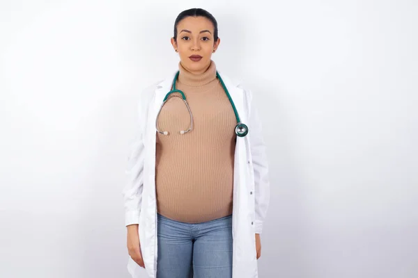 Vreugdevolle Zwangere Doktersvrouw Die Naar Camera Kijkt Aan Iets Denkt — Stockfoto