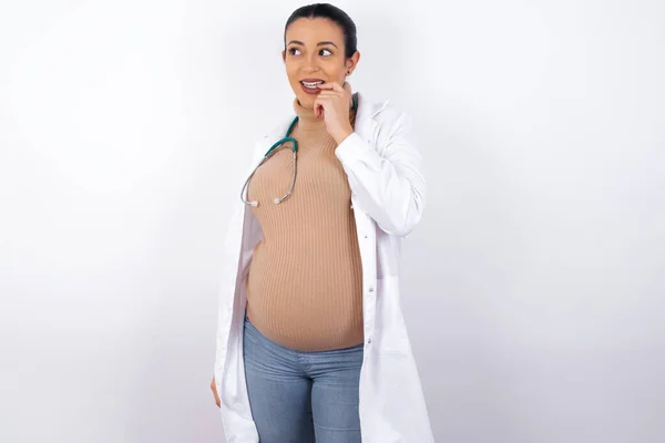 Schwangere Ärztin Mit Nachdenklichem Gesichtsausdruck Blickt Die Kamera Hält Die — Stockfoto