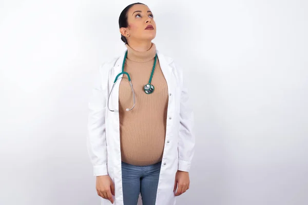 Embarazada Médico Mujer Vistiendo Uniforme Médico Mirando Hacia Arriba Como —  Fotos de Stock