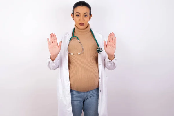 怀孕的医生妇女别再用手掌唱歌了 脸上带有消极而严肃的手势的警告表情 — 图库照片