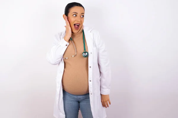 Mujer Doctora Embarazada Emocionada Mirando Lado Con Mano Cara Concepto — Foto de Stock