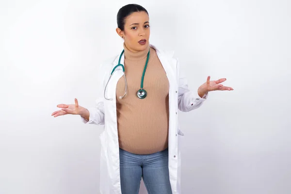 Grávida Médico Mulher Vestindo Uniforme Médico Parece Incerto Ombros Encolhe — Fotografia de Stock