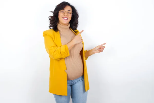 Schwangere Frau Mit Positivem Ausdruck Zeigt Mit Dem Zeigefinger Auf — Stockfoto