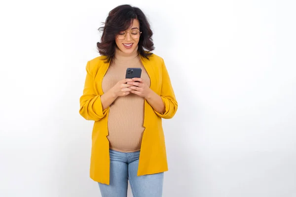 Lächelnde Schwangere Gelben Blazer Handy Sms Sms Mit Freunden Blick — Stockfoto