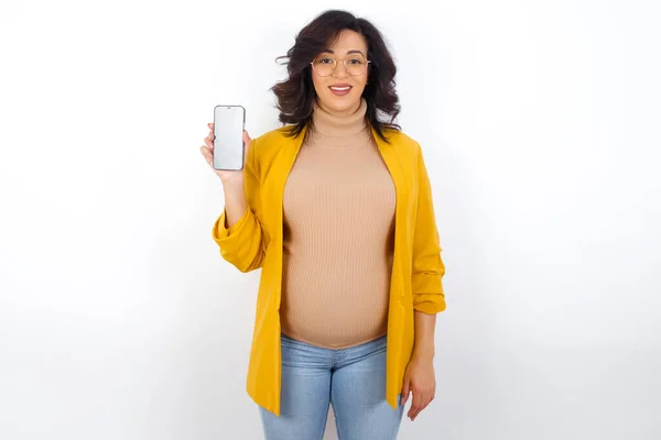 Usmívající Těhotná Žena Žlutém Blejzru Ukazujícím Prázdnou Obrazovku Koncept Reklamy — Stock fotografie