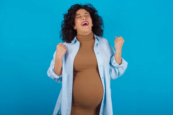 腕を上げて目を閉じて驚くべき成功を祝う妊婦さん 勝者のコンセプト — ストック写真