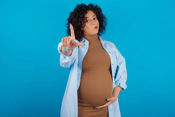 妊娠したアラブの女性は 失われたジェスチャーを嘲笑し侮辱する額に指を持つ人々を楽しみます — ストック写真