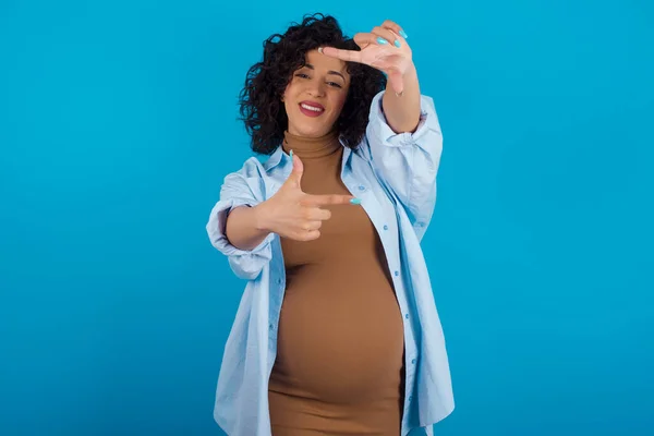 妊娠中の女性が手で指のフレームを作る 創造性と写真の概念 — ストック写真