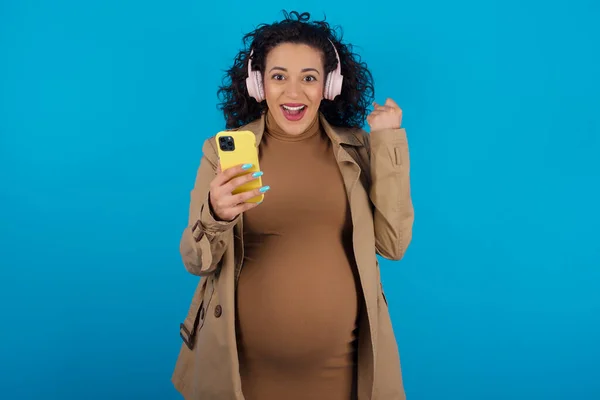 Positiv Schwangere Araberin Hält Modernes Handy Kopfhörer Ballt Die Faust — Stockfoto