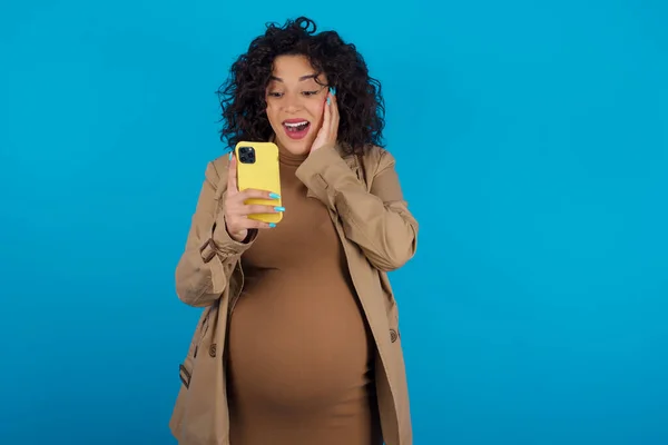 新しいアプリを使用してSmsを読んでいる手の携帯電話で保持している妊婦 — ストック写真