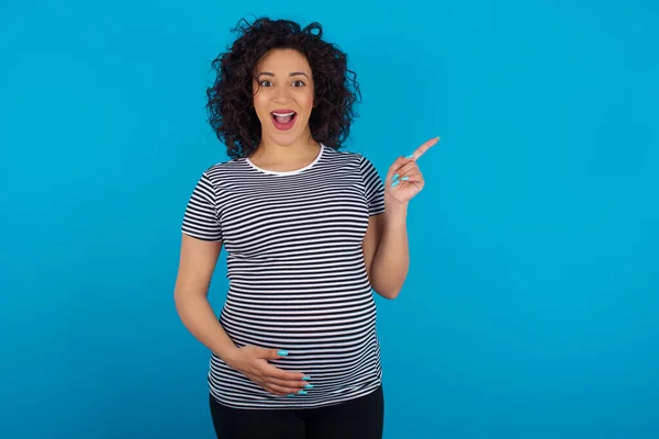 Pregnant Arab Woman Wearing Striped Shirt Points Aside Copy Blank — Stock Photo, Image