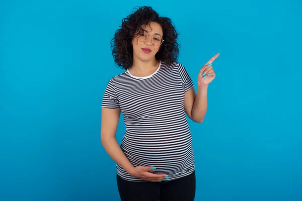 Mulher Grávida Árabe Vestindo Listrado Shirt Aponta Para Lado Espaço — Fotografia de Stock