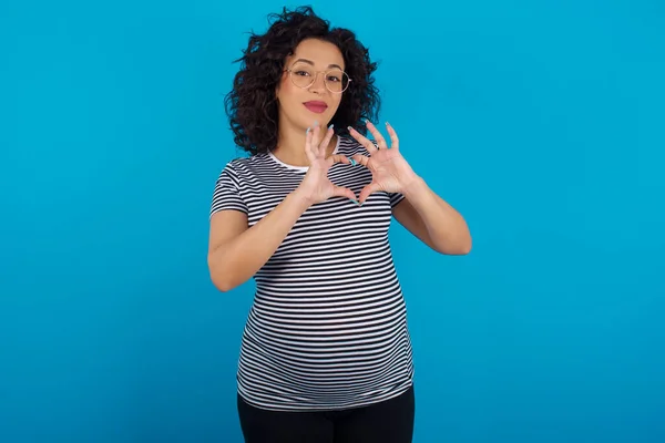 Ernstige Zwangere Arabische Vrouw Draagt Gestreept Shirt Houdt Handen Gekruist — Stockfoto