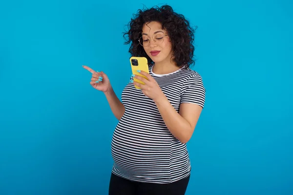 Smiling Pregnant Arab Woman Wearing Striped Shirt Pointing Finger Blank — Stock Photo, Image