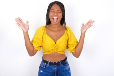 Çılgın öfkeli genç kadın sarı bluz giyen ve yüksek sesle bağıran kot giyen güzel kadın. 