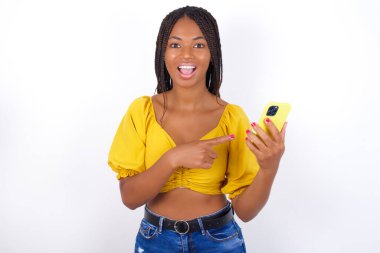 Hoş bir portre sarı bluz ve akıllı telefondan etkilenmiş güzel bir kadın.