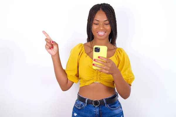 Smiling Young Beautiful Woman Wearing Yelllow Top Jeans Pointing Finger — Stock Photo, Image