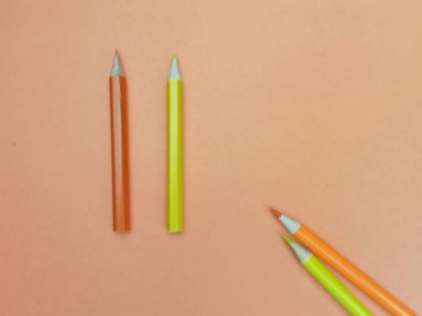 Yumuşak şeftali arkaplana yerleştirilmiş dört renkli kalemden oluşan minimalist kompozisyon ve geniş kopya alanı. Eğitim temaları, yaratıcı projeler, okul gereçleri, sanat malzemeleri ve promosyon tasarımları için uygun parlak kırtasiye düzeni. İdeal 