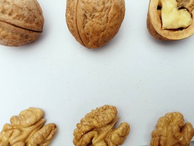 Kabuklu ceviz ve kabuklu ceviz çekirdekleri beyaz arka planda dizilmiş. Sağlıklı yeme, beslenme, yemek pişirme ve gıda paketleme için doğal fındık karşılaştırma kavramı. Kopya alanı olan düz konum.