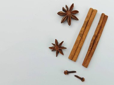 Beyaz arka planda yıldız anason ve karanfilli tarçın çubukları. Kopyalama alanı, pişirme ve pişirme konsepti olan en düşük baharat bileşimi.