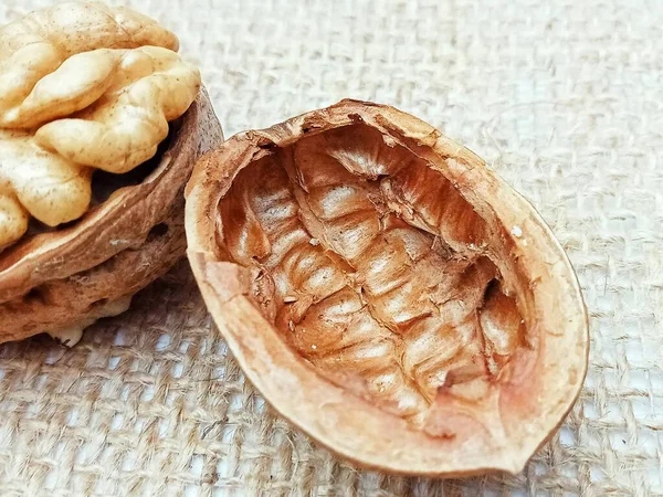 Kırsal çuval bezine boş ceviz kabuğu. Doğal doku arka planı, organik gıda konsepti, kopyalama alanı olan minimum bileşim.