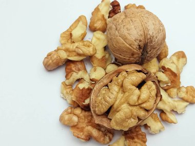 Ceviz çekirdekleri beyaz arka planda bir ceviz ile dağılmış. Omega yağı, protein ve vitamin açısından zengin sağlıklı besin maddeleri. Kopya alanı ile doğal beslenme kavramı.