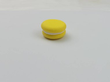 Beyaz arka planda sarı makarna. Fotokopi alanı, yiyecek reklamları, ambalaj tasarımı, fırın markalaştırma, şekerleme promosyonu ve modern mutfak projeleri için uygun en az tatlı konsepti. Renkli bir tatlı serisinin bir parçası..