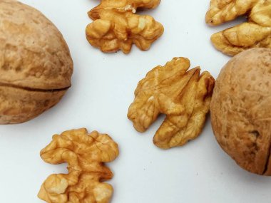 Kabuklu cevizler ve beyaz arka planda sıralanmış ceviz çekirdekleri. Doğal organik gıda, sağlıklı beslenme konsepti, fotokopi alanı ile düz konum..