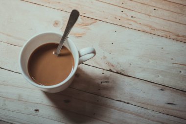 Eski ahşap üzerinde sıcak kahve fincanı. 