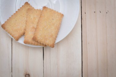 Beyaz tabakta kurabiyeler. Tahta masada..