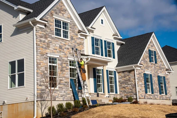 Double Gable Colored Stone Facade Siding White Frame Vinyl Shutters Stock Image