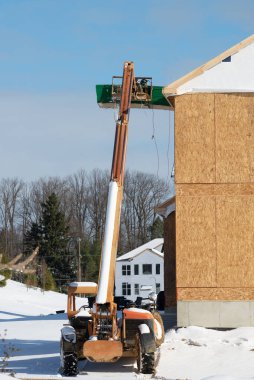 İnşaat alanındaki bir forklift, inşaat parçalarını hidrolik açık havada kaldırmaya hazırlanıyor.