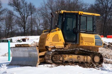 Kar altında traktör. Soğuk iş sarısı.